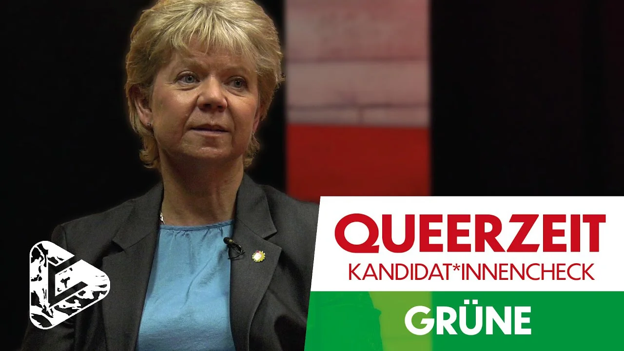 Frau in grauer Jacke vor Wahlkampf-Grafik mit Logo der Grünen und Text "QUEERZEIT KANDIDAT*INNENCHECK