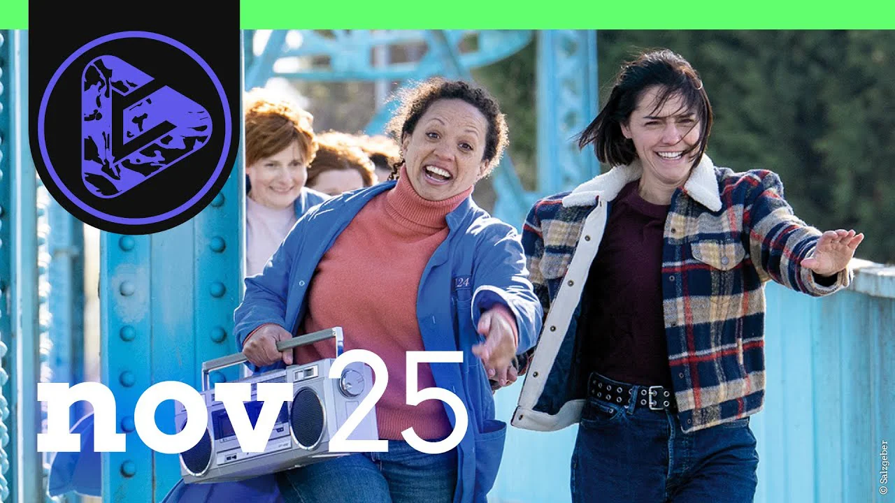 Drei fröhliche Frauen gehen Hand in Hand über eine blaue Brücke, eine trägt einen Retro-Kassettenrekorder.